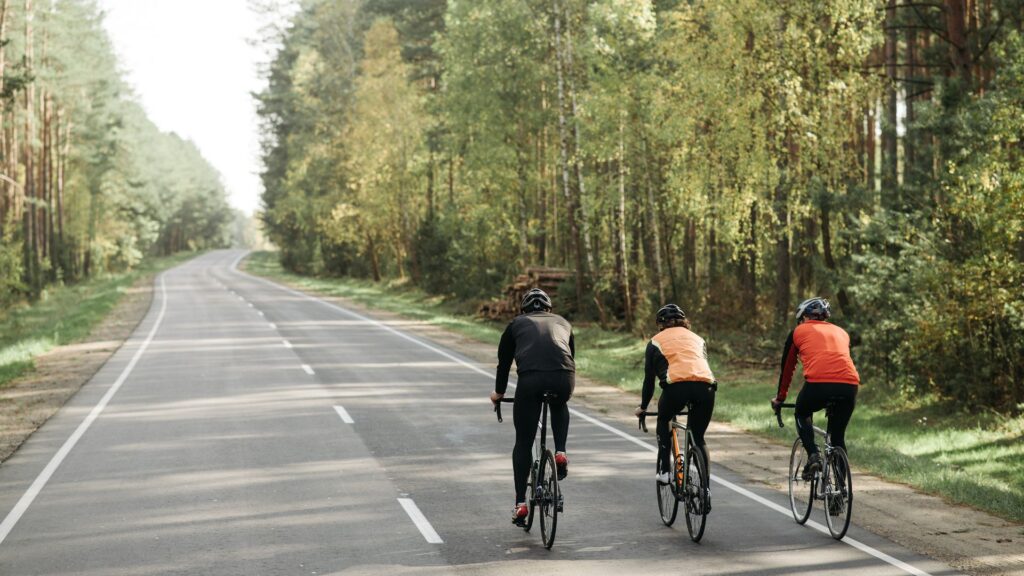 Three bikers riding on a whole road.