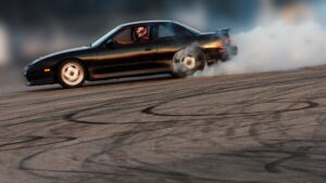 A black sedan doing donuts on the street.