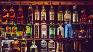 A wall of alcohol perfectly lined up in a bar.