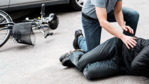 A person making sure a an injured bicyclist is alright.