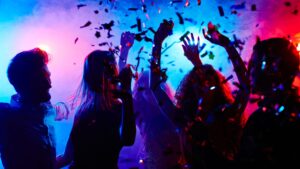 A bunch of people dancing in a dark nightclub.