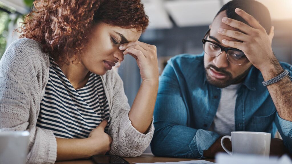 A couple in grief, looking sad and emotional.