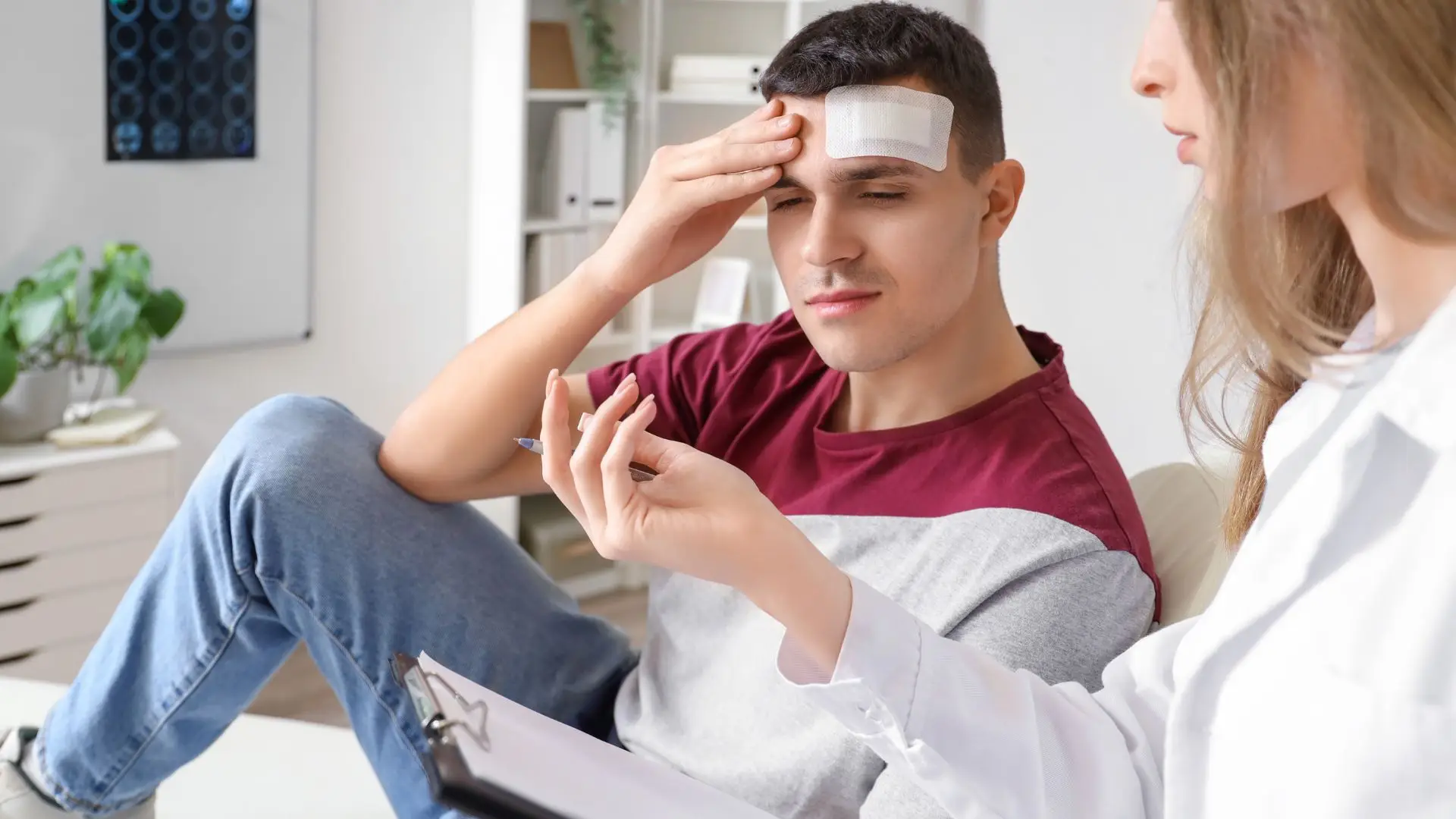 A man with a head injury getting an explanation by his doctor.