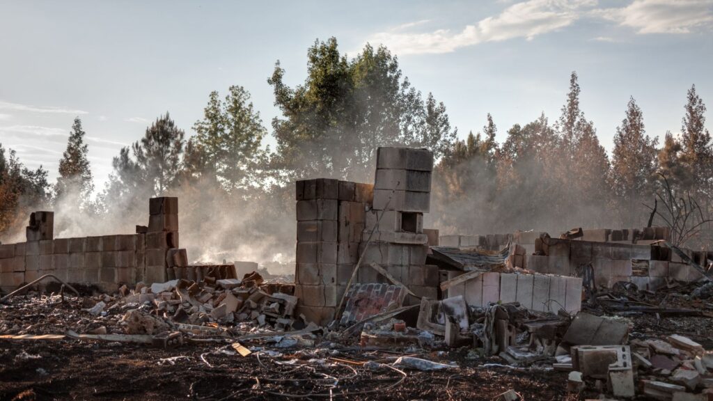 A home that is burnt and destroyed by a wildfire.