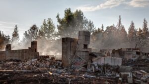 A home that is burnt and destroyed by a wildfire.