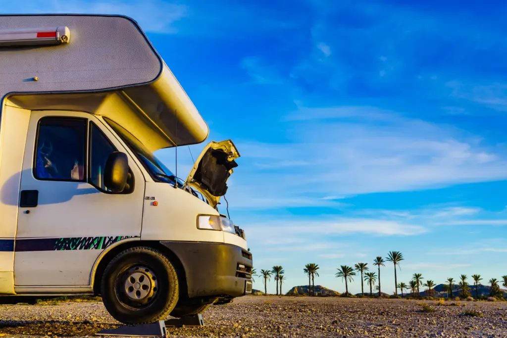 A broken RV in the middle of the desert.