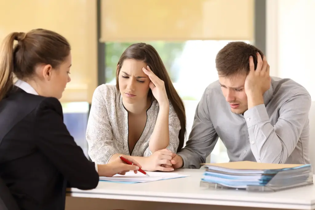 A concerned couple looking at a sheet of paper.