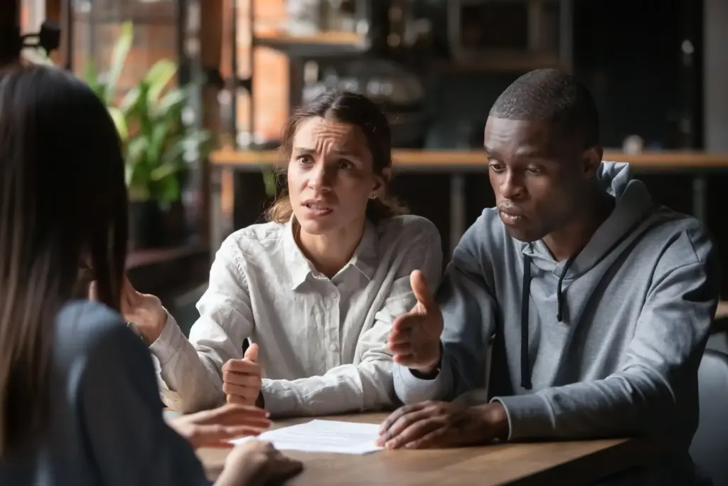A stressed couple arguing something to a person.