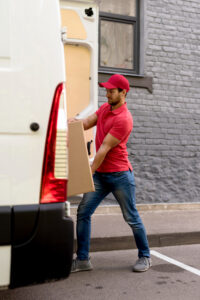 amazon delivery man pushing package in the truck